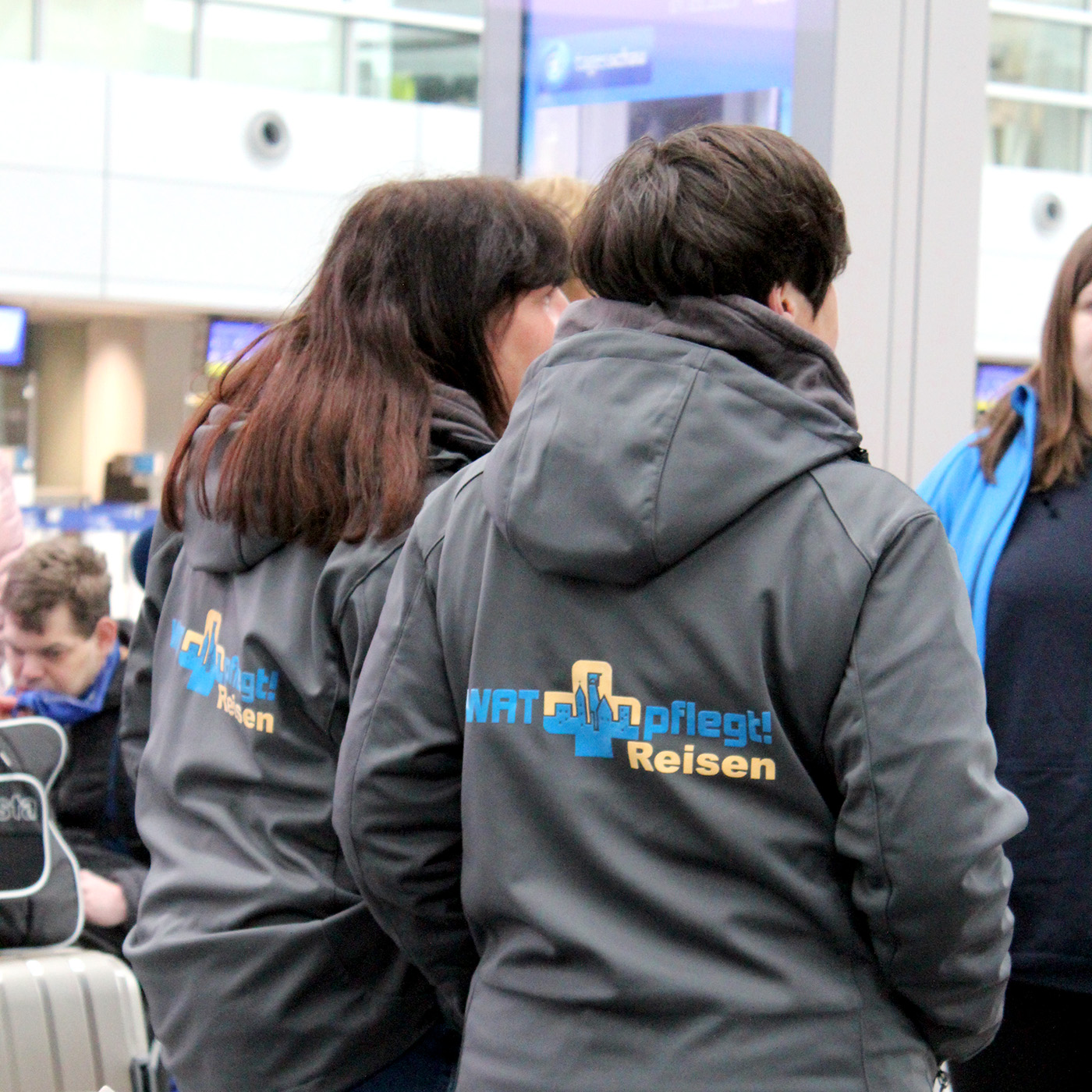 Zwei Damen unseres Reise-Teams unterhalten sich am Flughafen mit anderen Mitreisenden.